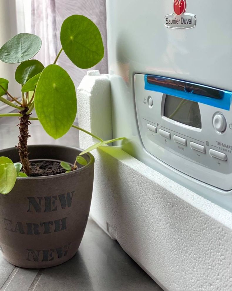 Un thermostat intelligent Ariston, fixé sur un mur blanc.