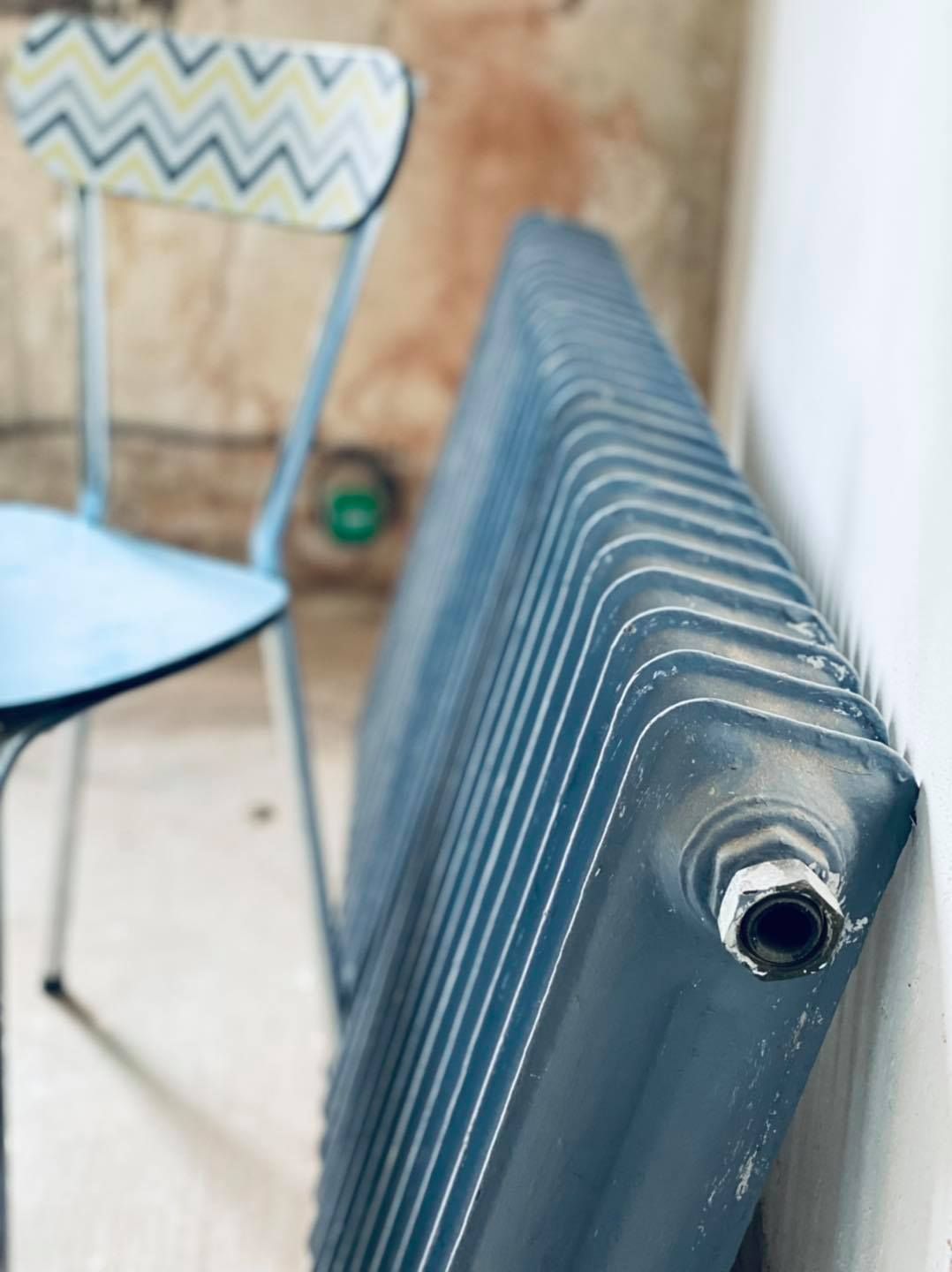 Une vanne thermostatique blanche de radiateur réglée sur la position hors gel sur un appareil de chauffage domestique.