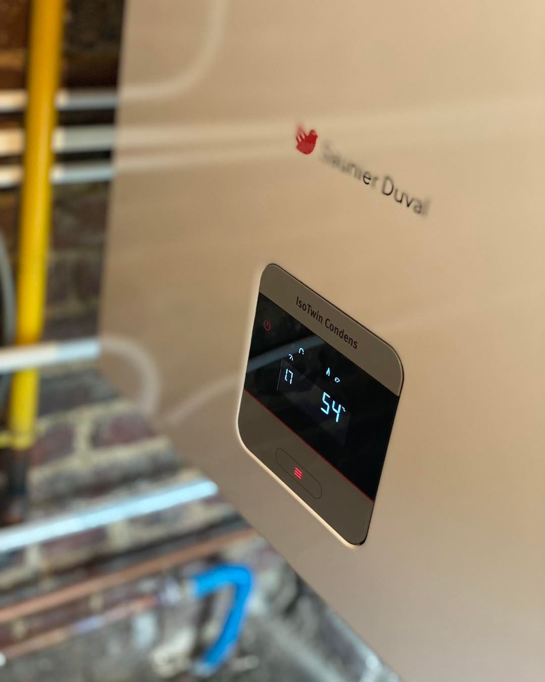 Une chaudière Saunier Duval contre un mur de briques