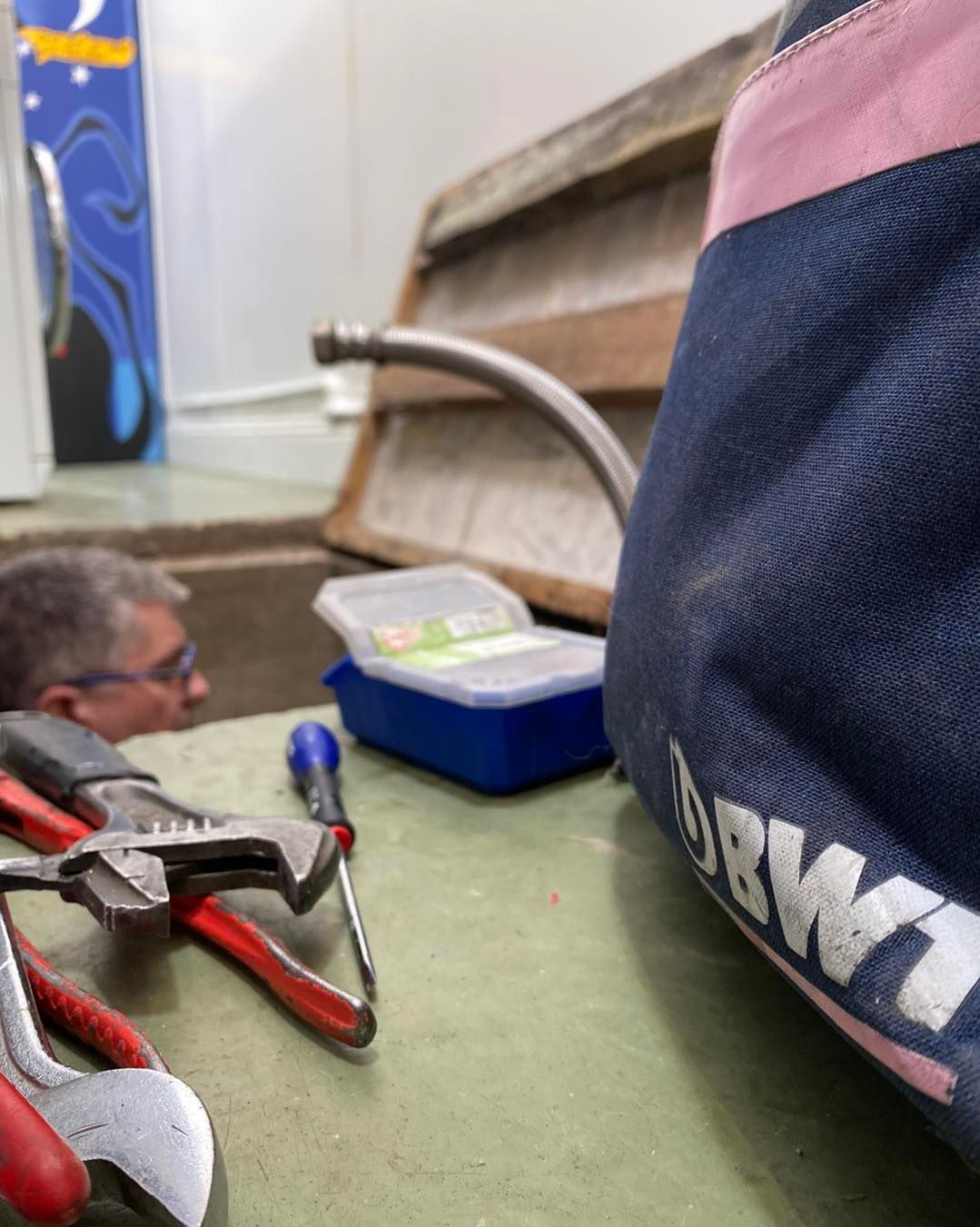 Une personne regarde par-dessus un établi encombré d'outils