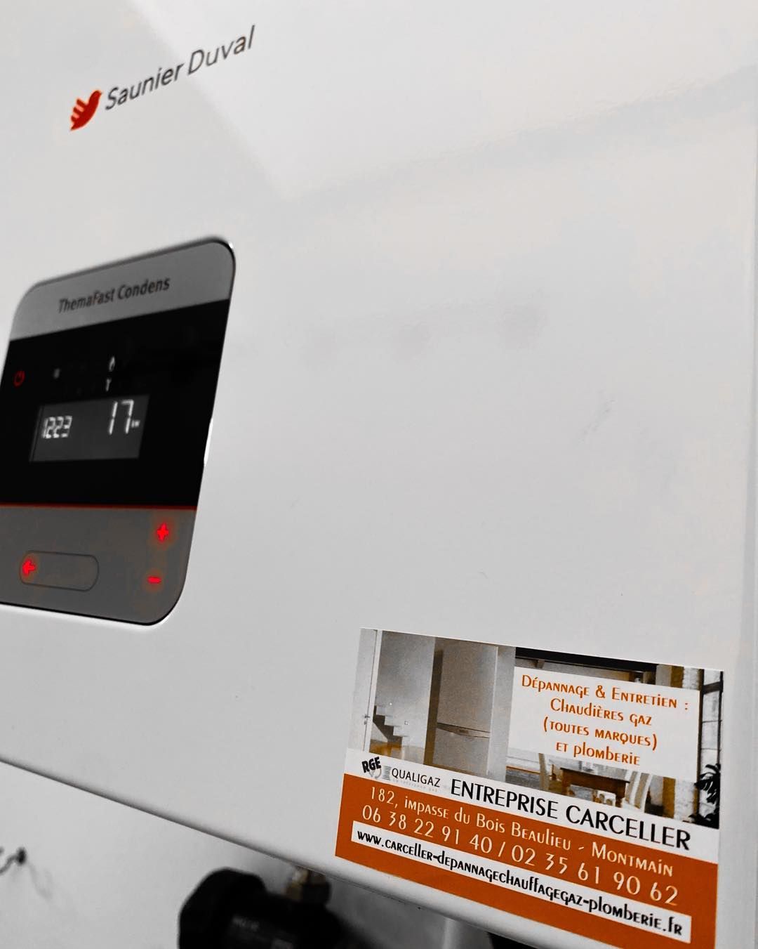 Gros plan d'une chaudière et autocollant avec coordonnées de l'entreprise