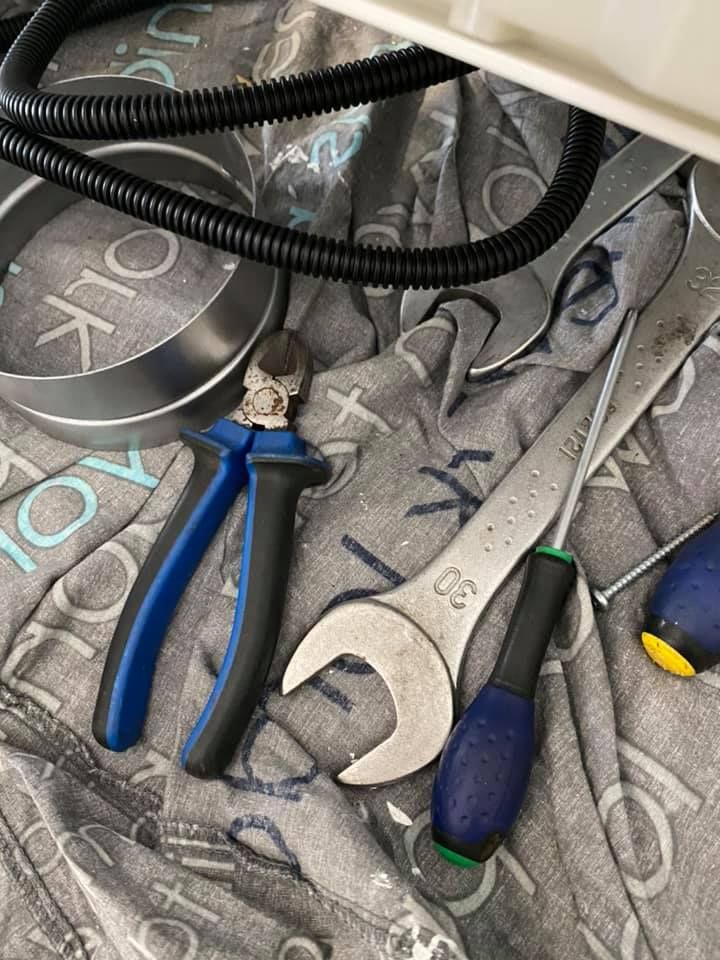 Des outils, notamment une pince, une grande clé et deux tournevis, disposés sur une surface en tissu