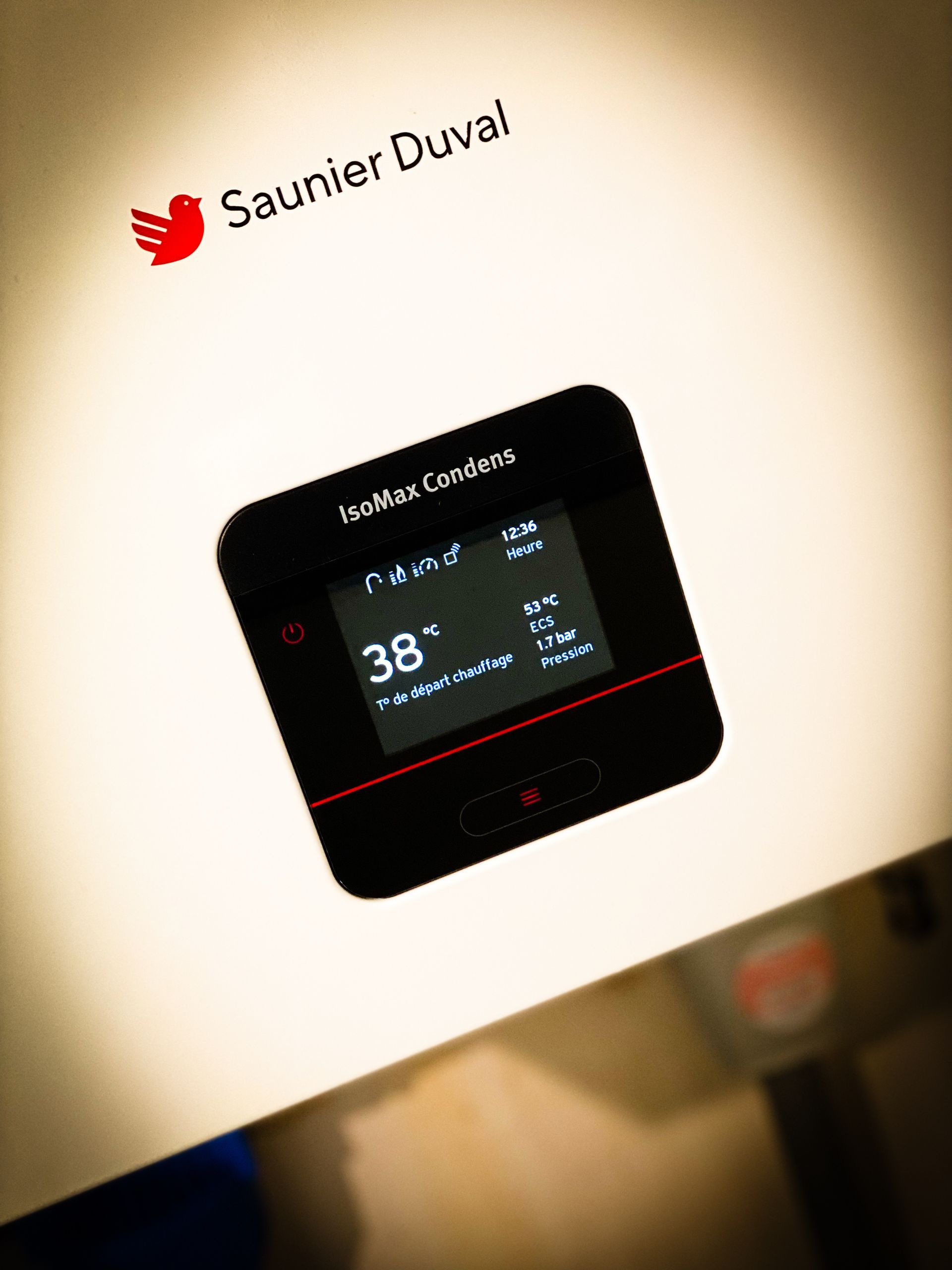 Un affichage numérique sur une chaudière Saunier Duval blanche indiquant une température de 38 °C.