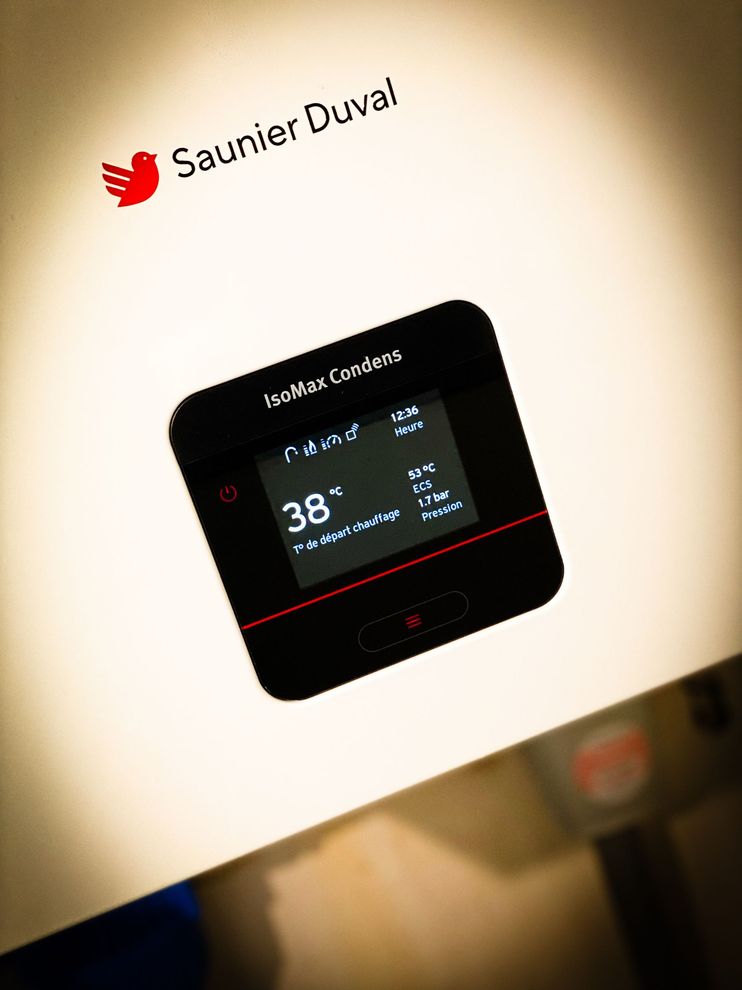 Une chaudière Saunier Duval avec un affichage numérique du thermostat indiquant une température de 38 °C.