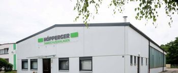Person im Schutzanzug reinigt einen Tank