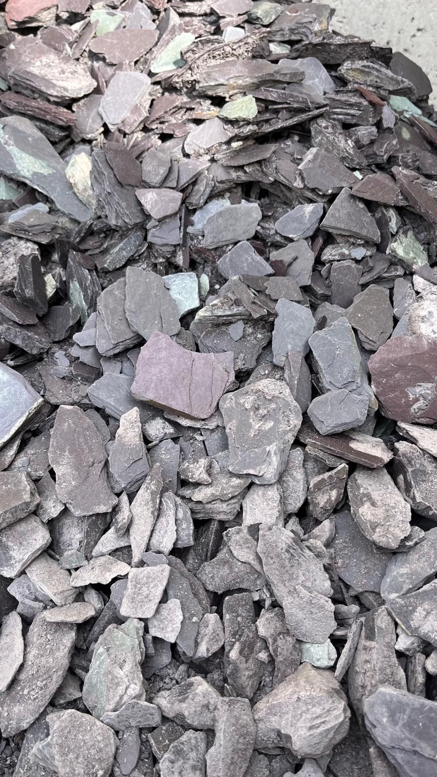 Tas de roches concassées grises et roses et de débris sur le sol