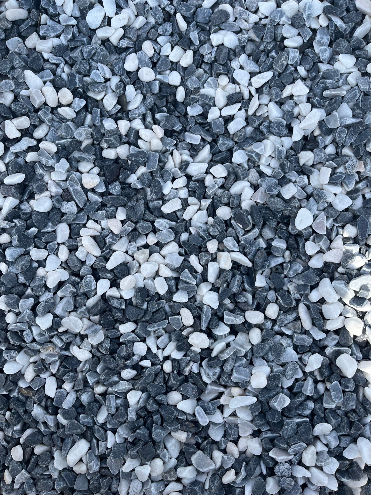 Gros plan sur de petits cailloux gris et blancs éparpillés sur le sol
