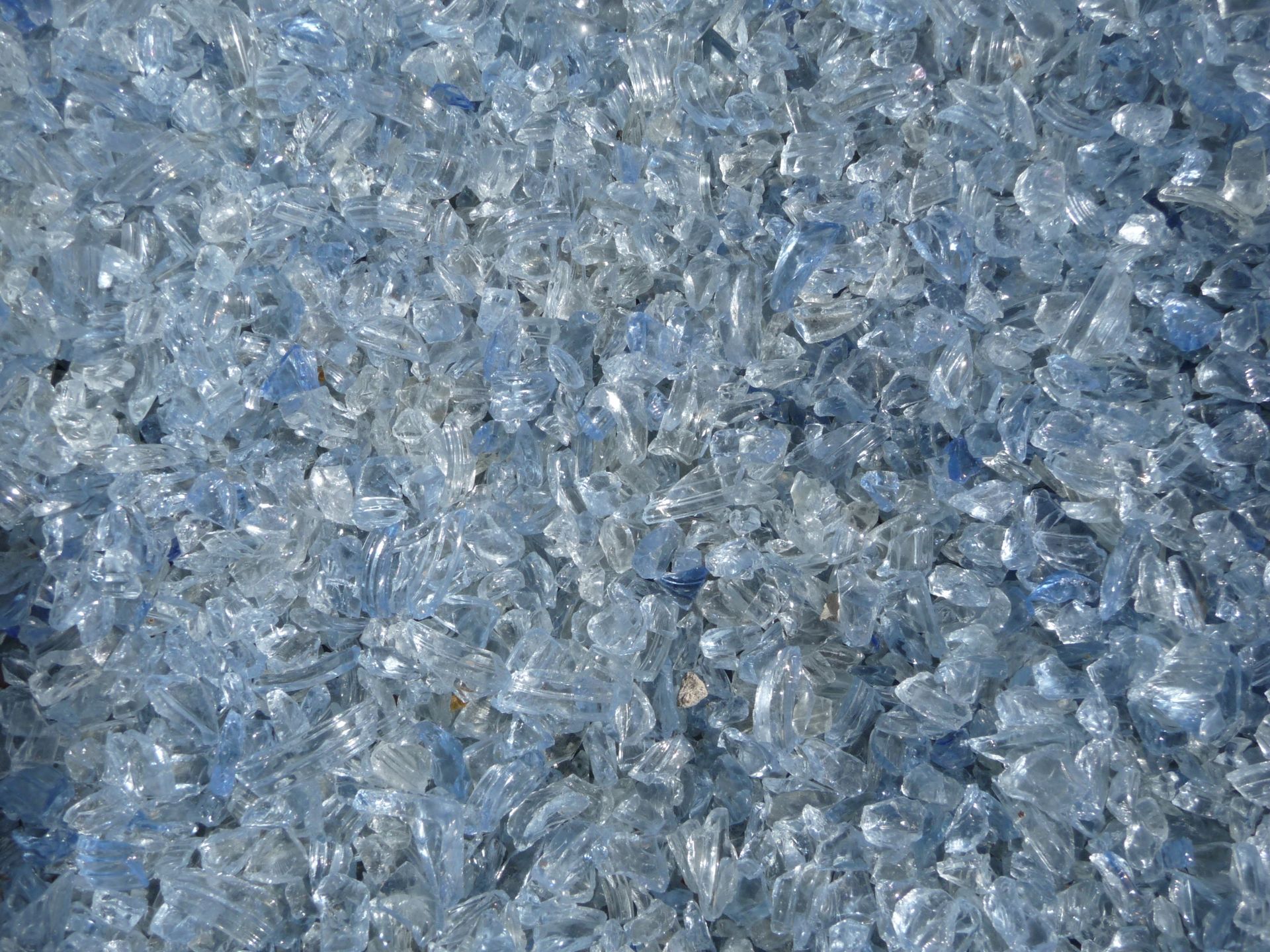 Gros plan sur des éclats de verre bleu concassé à la surface givrée et texturée