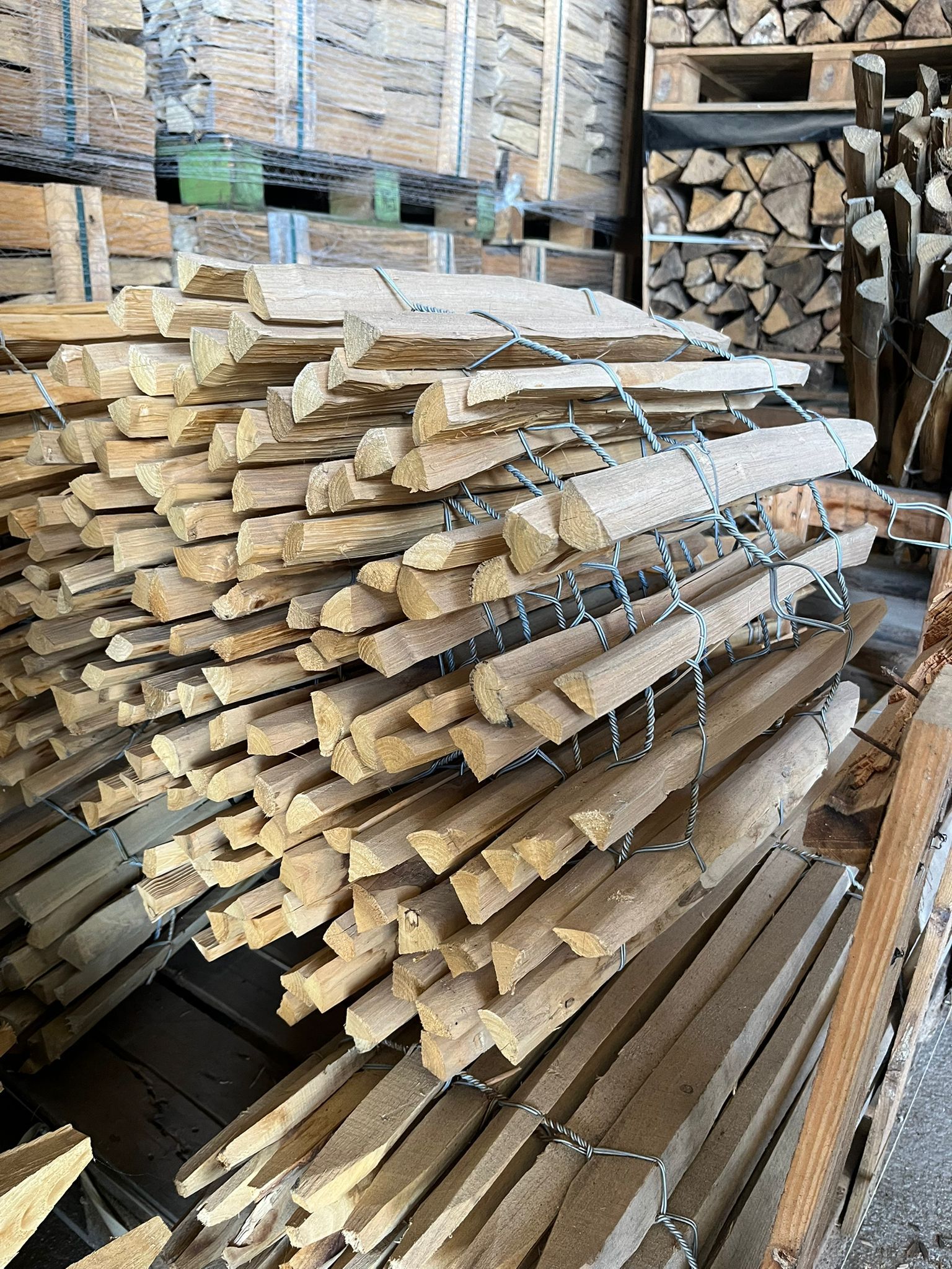 Faisceau de fines baguettes de bois attachées ensemble sur une surface en béton gris.