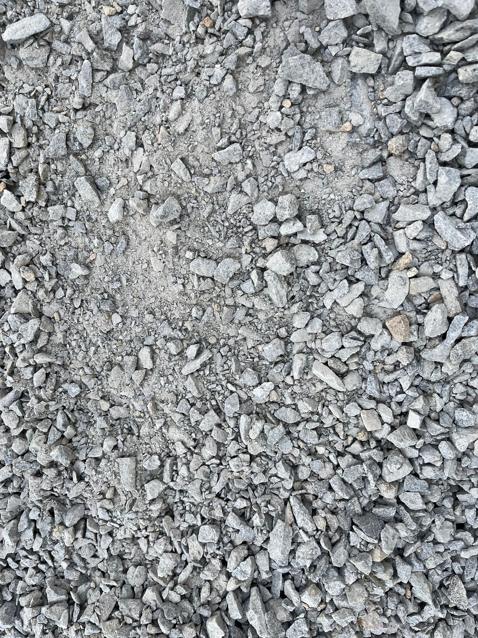 Gros plan sur du gravier gris et des petits cailloux remplissant le cadre