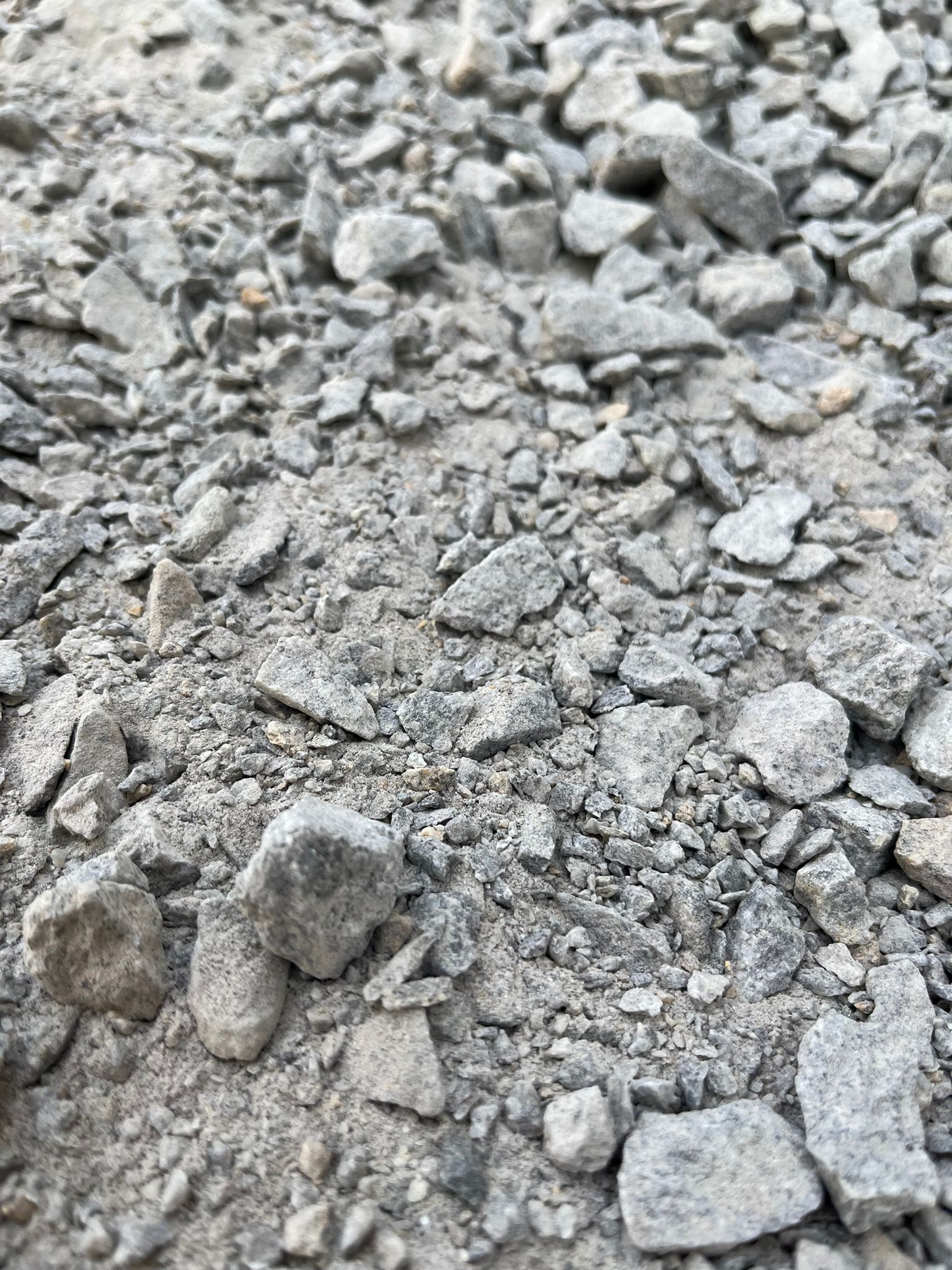 Gros plan sur du gravier gris et des petits cailloux remplissant le cadre