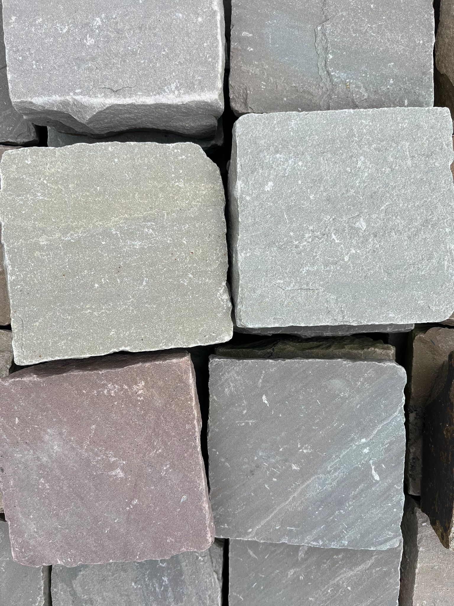 Gros plan sur des pavés gris et roses disposés en une grille serrée.