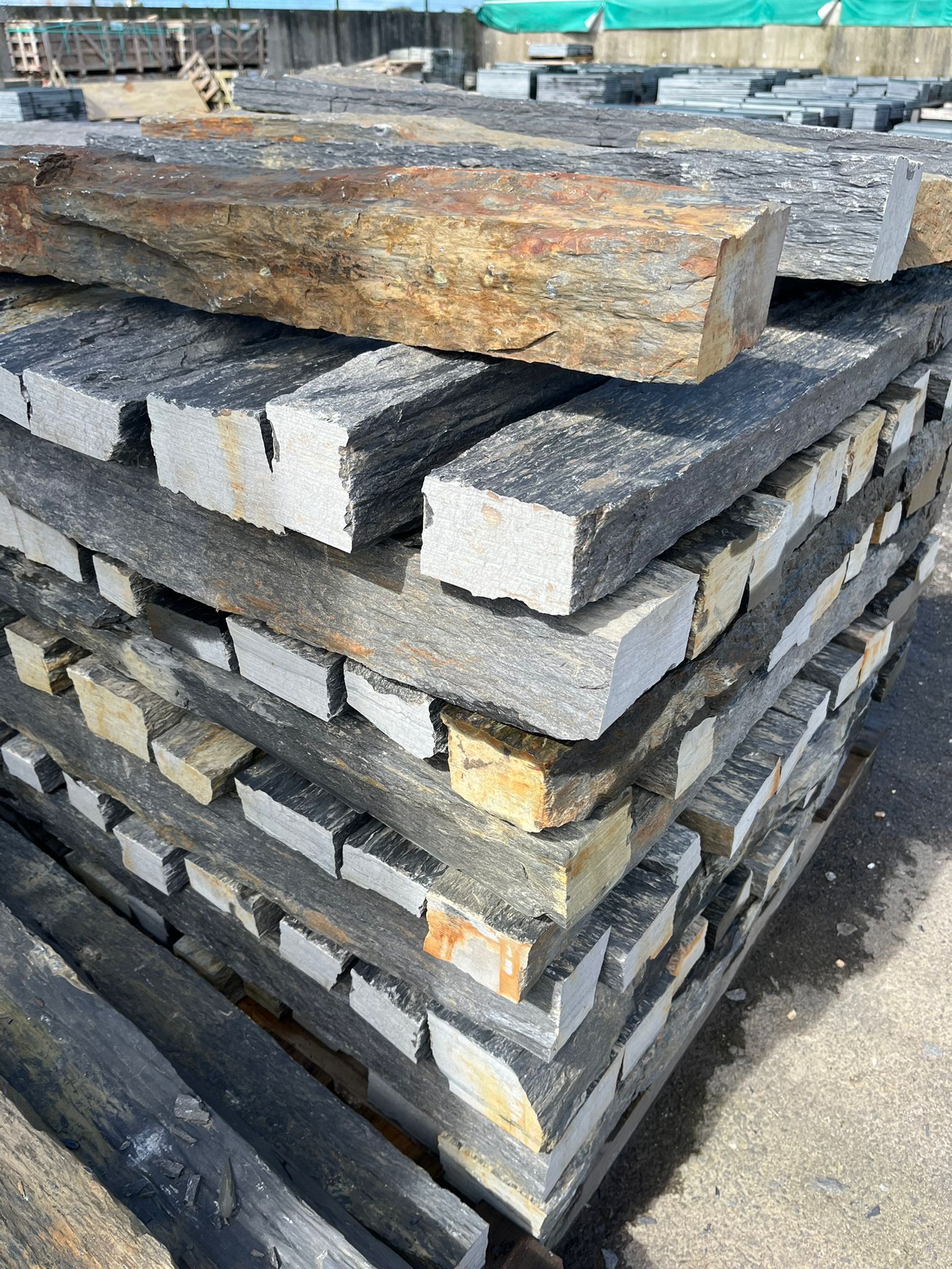 Des dalles de pierre brute empilées sur un chantier de construction