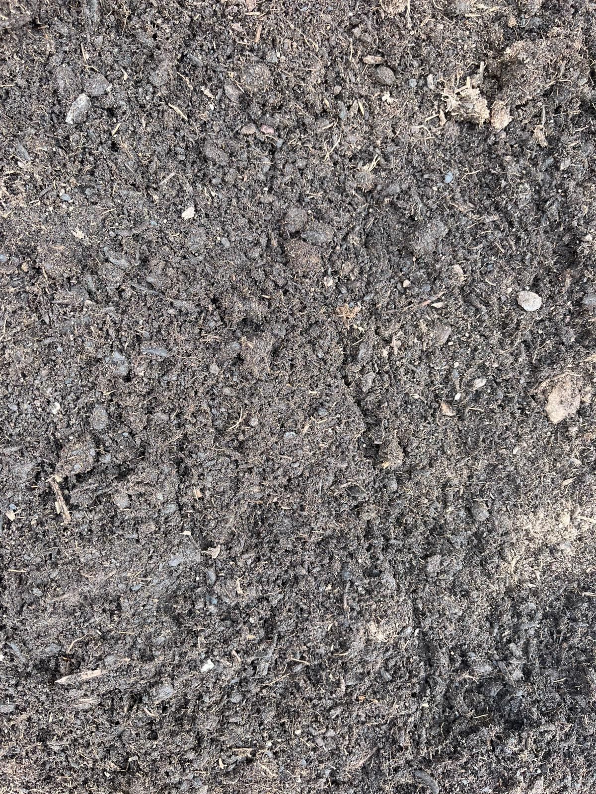 Gros plan sur une surface de gravier gris rugueux et d'asphalte parsemée de petits cailloux.