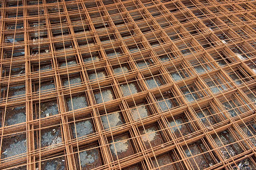 Treillis d'armatures de couleur rouille recouvrant la façade d'un bâtiment en construction