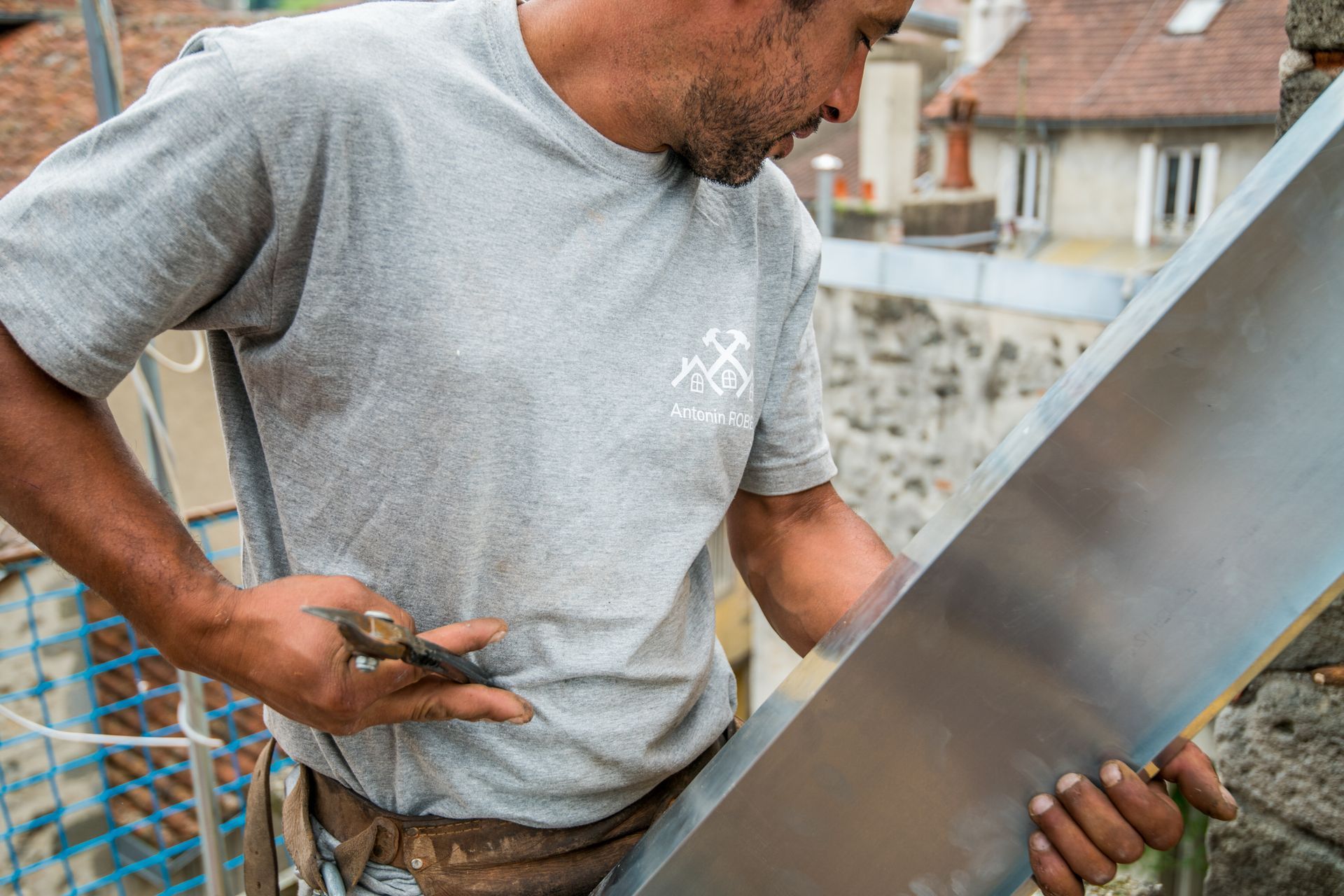 Homme qui répare une étanchéité à l'aide d'une plaque de zinc