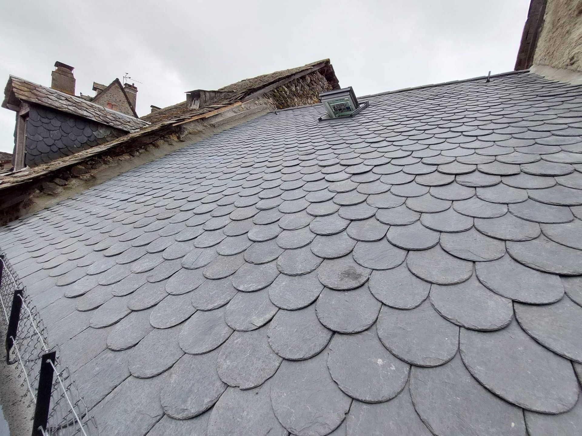 Une couverture en ardoise avec une fenêtre de toit