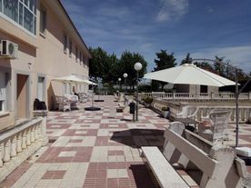 Un patio con sombrillas y bancos frente a un edificio.
