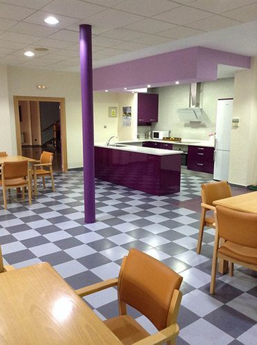 Una cocina con gabinetes morados y piso a cuadros.