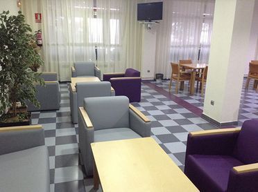 Una sala de estar con muchas sillas y mesas.