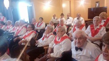 Un grupo de personas mayores están sentadas en una habitación.
