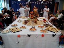 Un grupo de personas está sentada alrededor de una mesa decorada para Halloween.