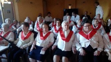 Un grupo de personas que llevan fajas rojas están sentadas en una habitación.