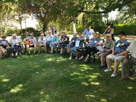 Un grupo de personas está sentada en círculo en un parque.