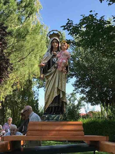 Una estatua de una mujer sosteniendo un bebé en un parque.