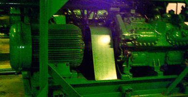 Maquinaria industrial verde, posiblemente un motor, en el interior.