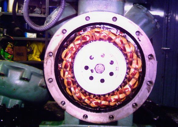 Vista abierta del estator de un motor industrial con cableado de cobre. Un anillo metálico lo sujeta.