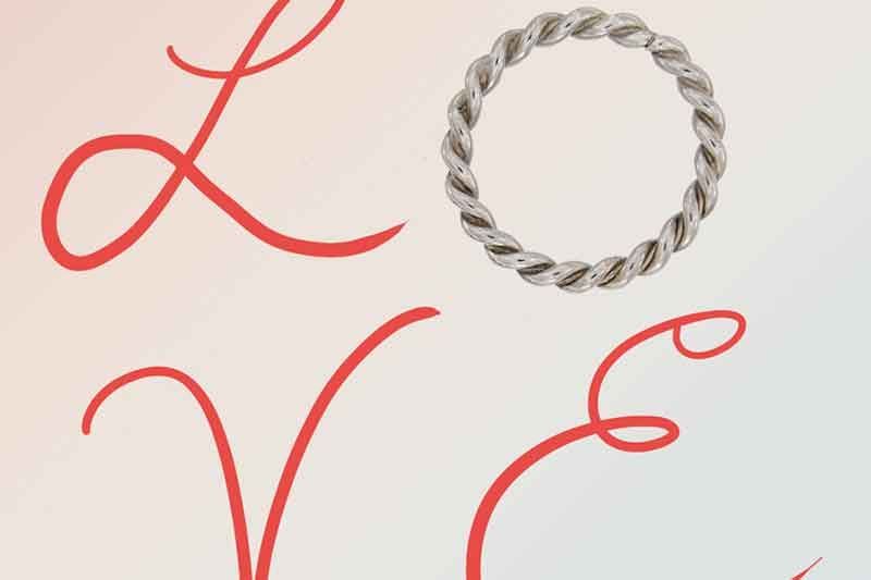 Gedrehter Silberring mit dem Wort „Love“ in roter Kalligrafie.