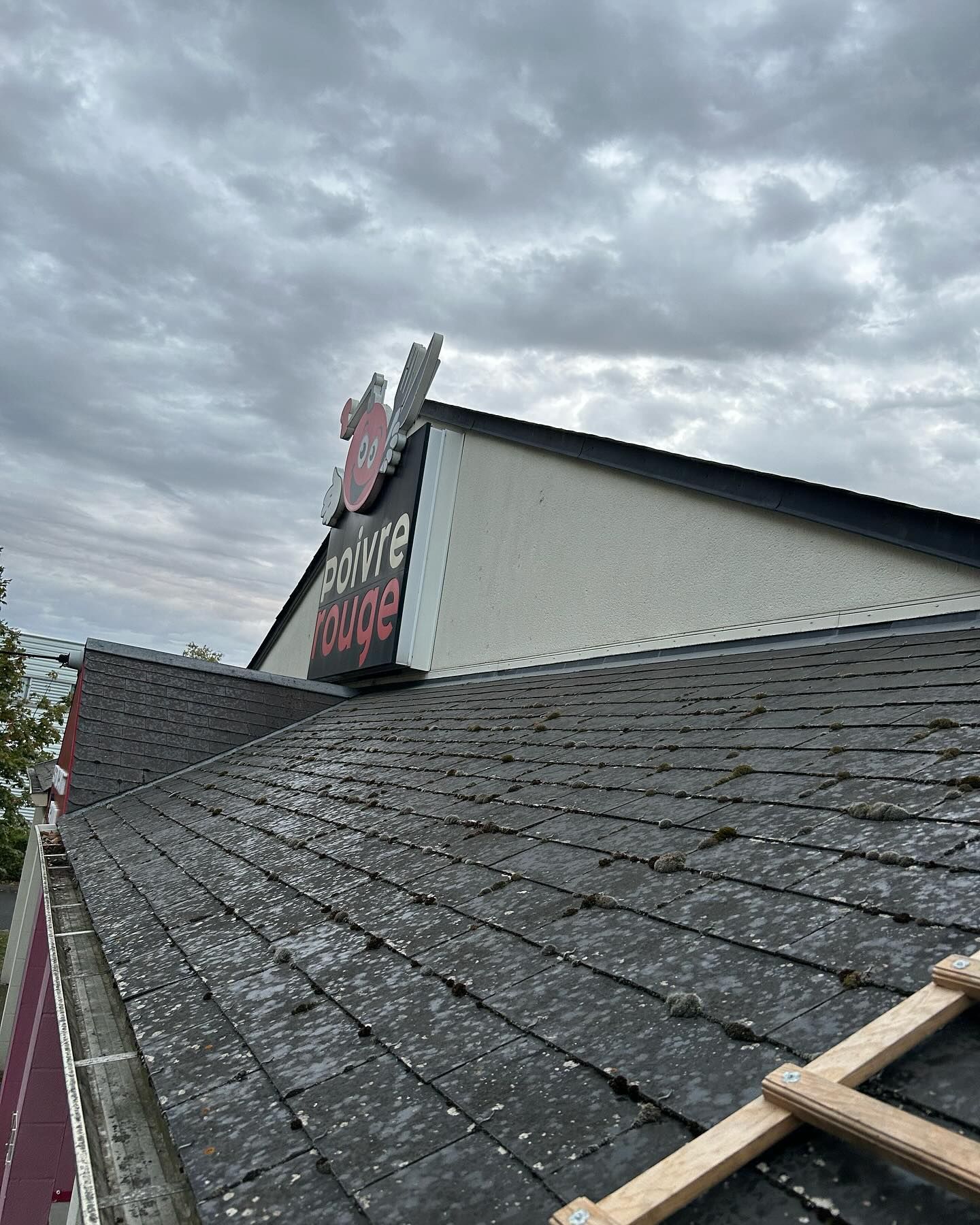 Toiture d'un restaurant Poivre Rouge avec de la mousse.