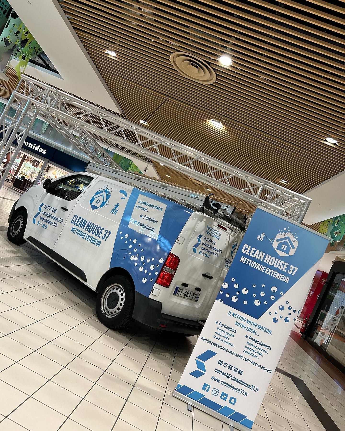 Véhicule de Clean House devant un stand.