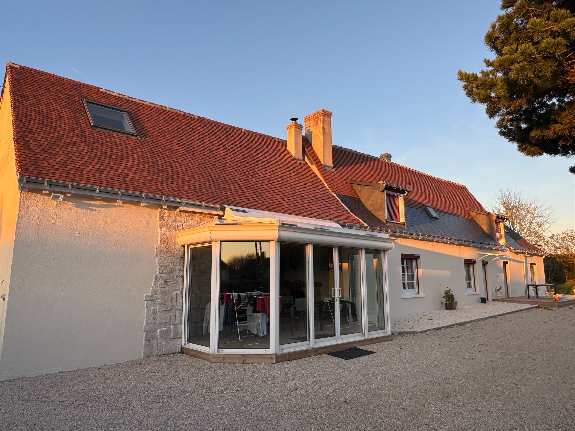 Belle toiture en tuiles et véranda en premier plan.