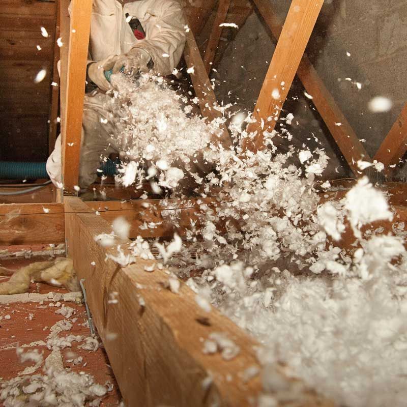 Employé qui remplie les combles de mousse isolante