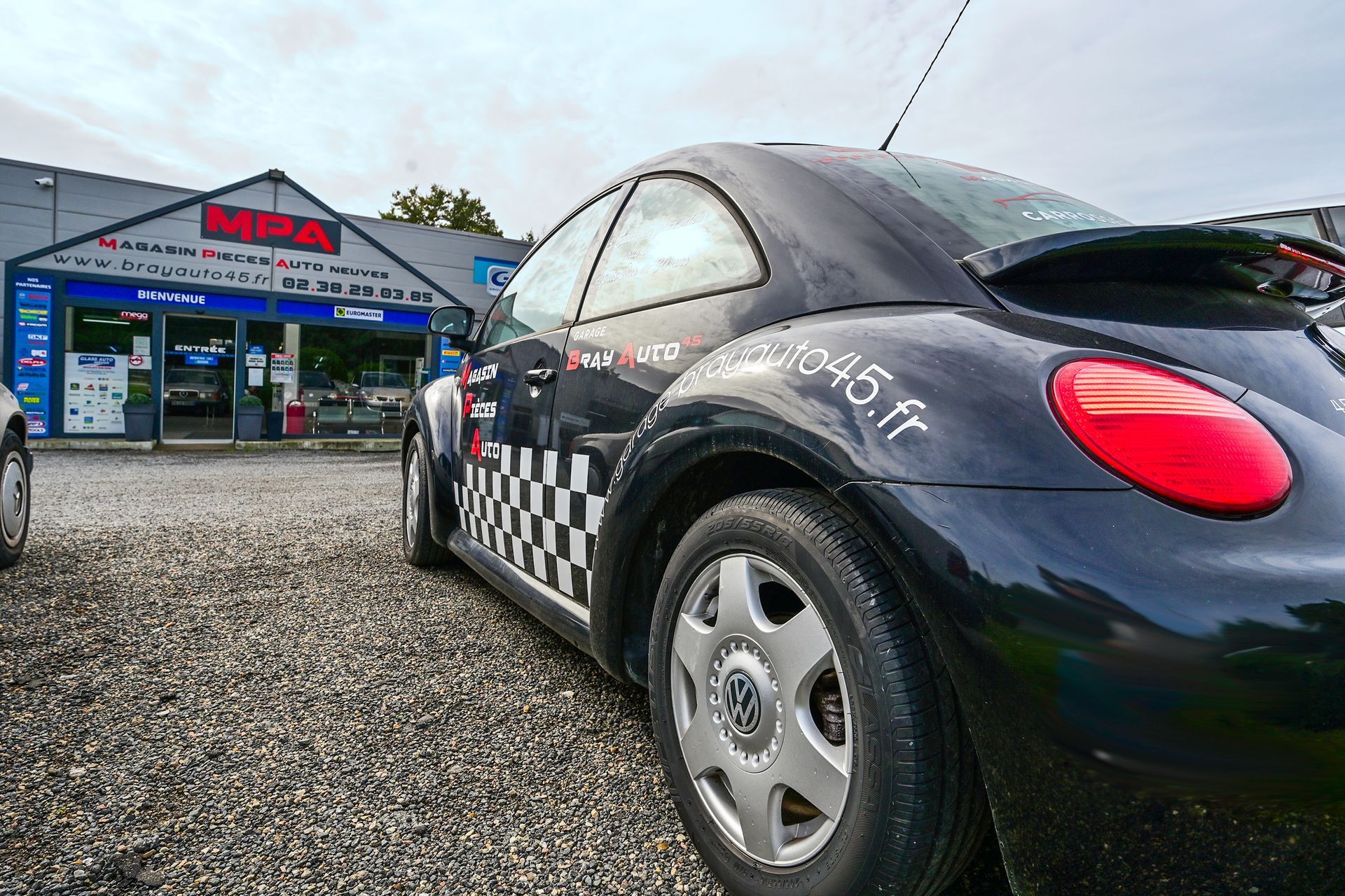 Gros plan sur le côté d'une voiture stationnée devant le garage.