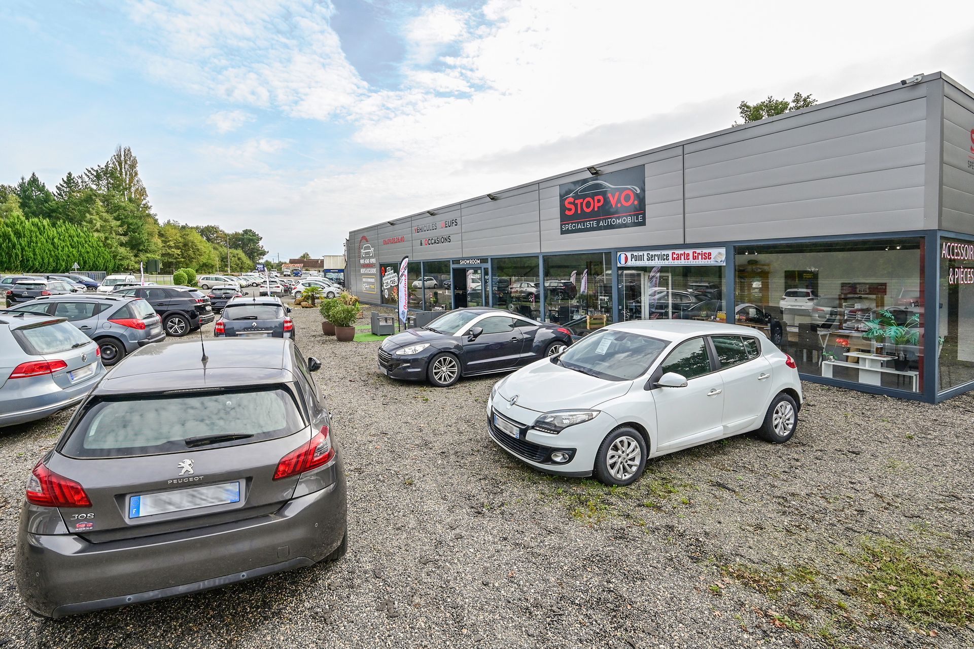 Plusieurs véhicules devant le garage automobile.
