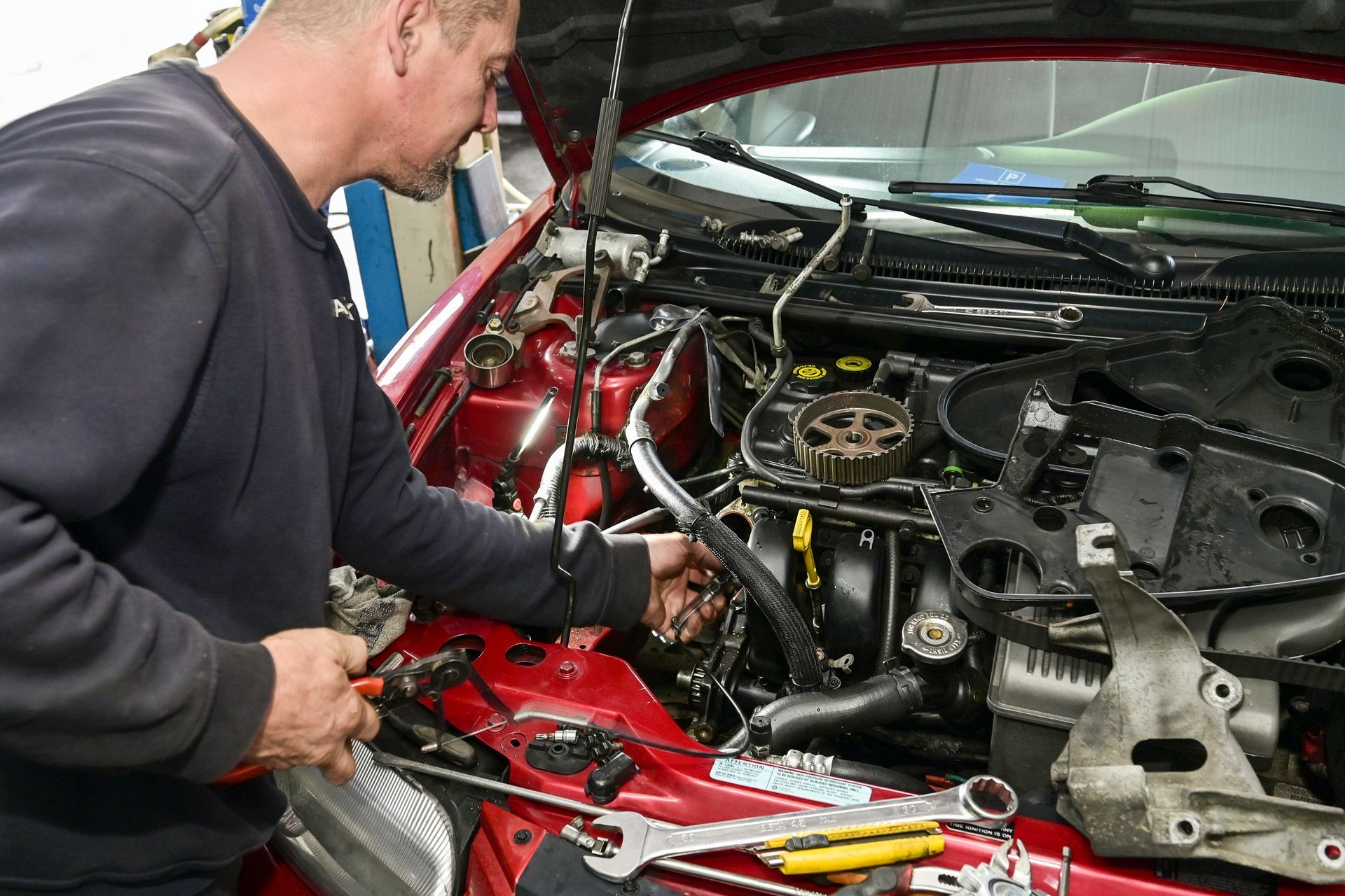 Un garagiste en train de réparer le moteur d'une voiture.