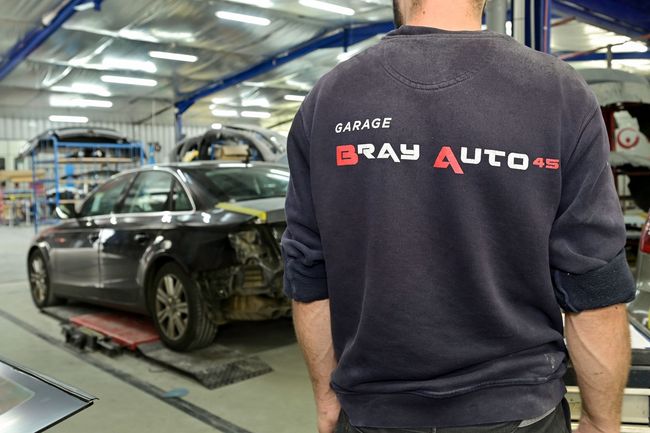L'employé du garage avec le pull du garage.