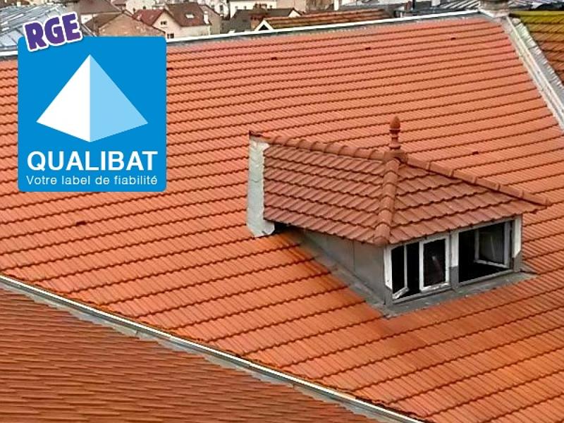Un toit de tuiles avec une petite lucarne, et le logo de certification Qualibat RGE dans un coin.