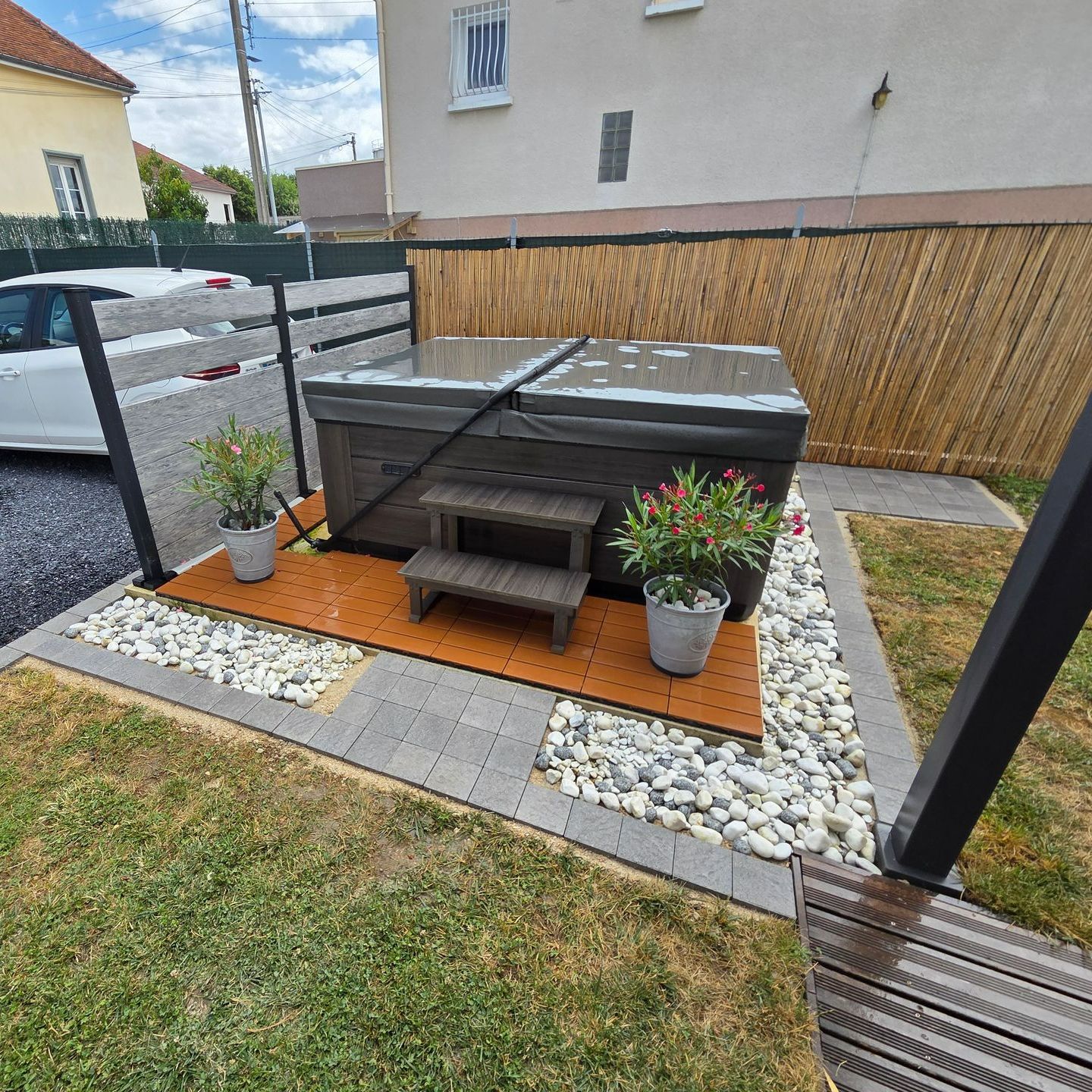 Aménagement extérieur d'une terrasse en pavés et pierres pour un Jacuzzi