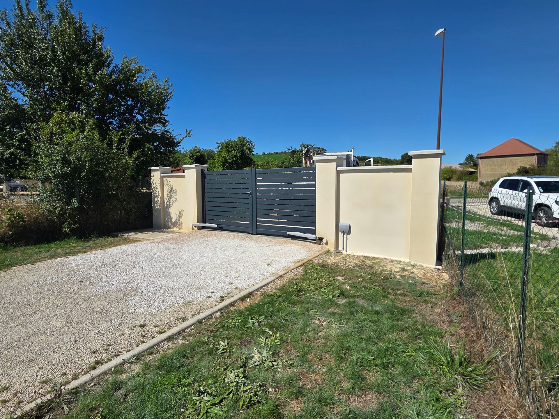 Murette avec crépi avec un portail noir