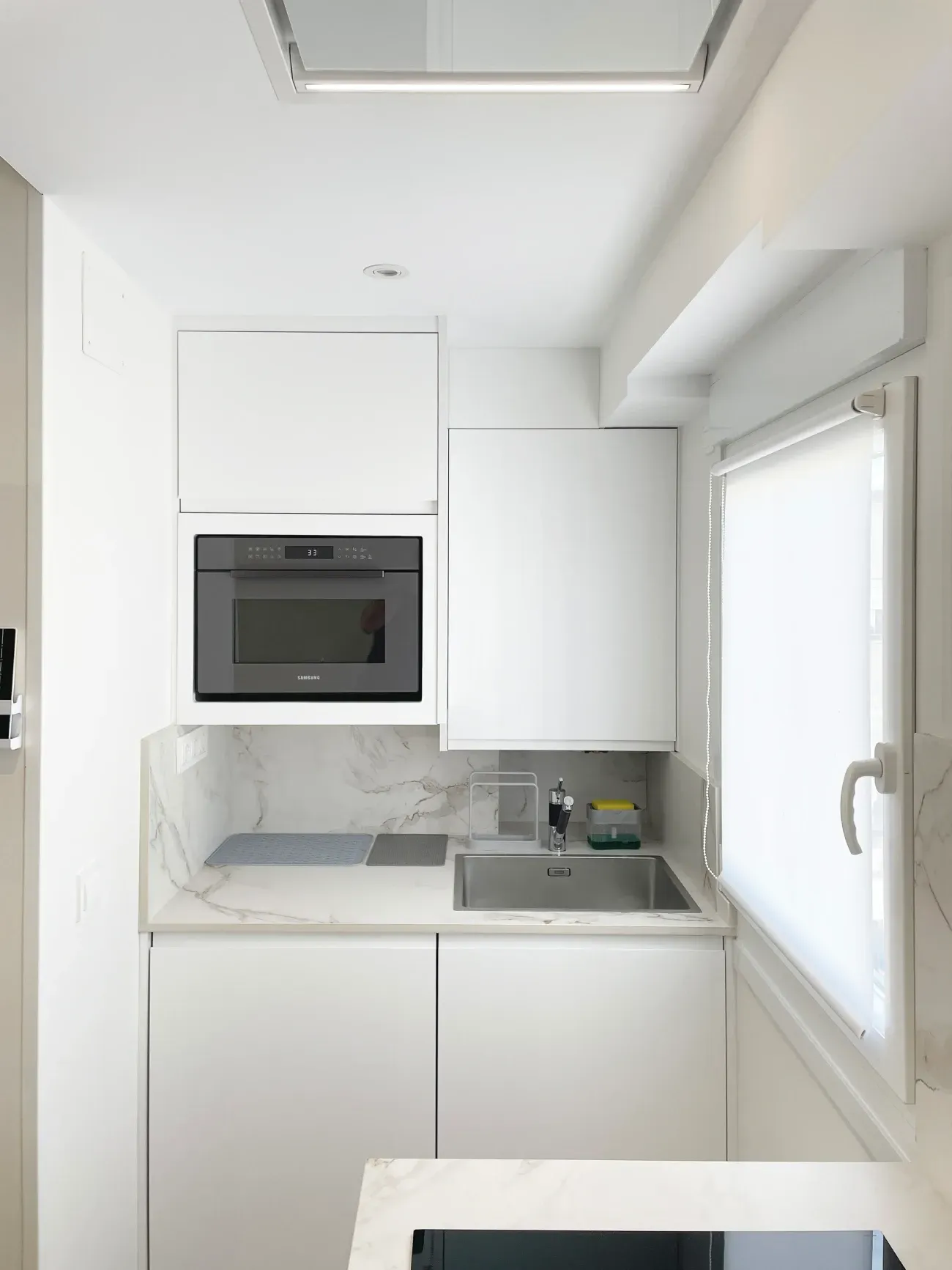 Cocina pequeña, moderna y completamente blanca.