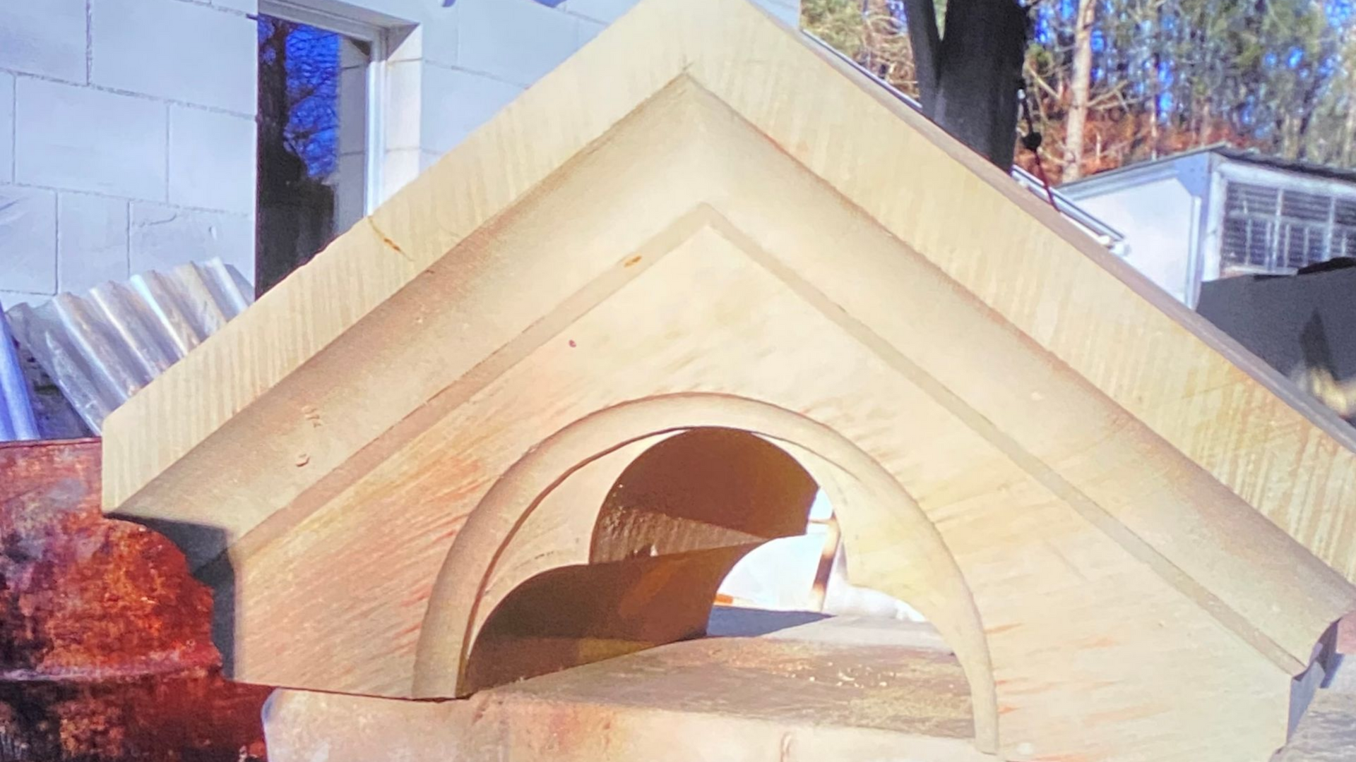 Structure en pierre avec arche et toit triangulaire.