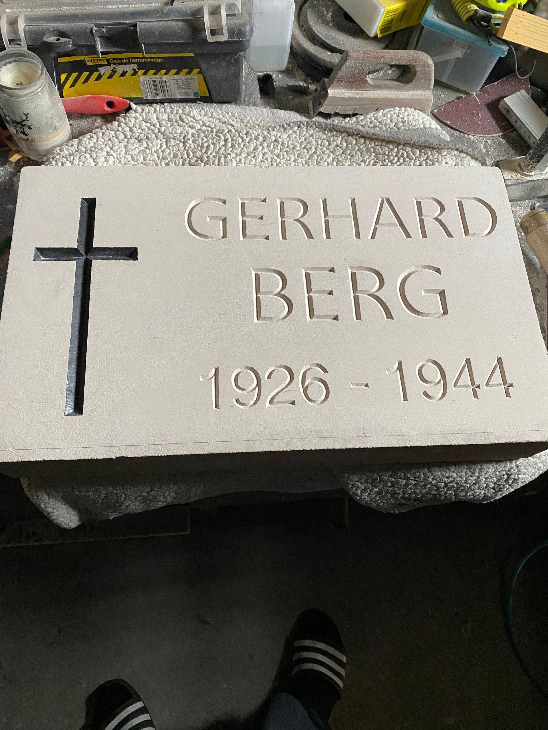 Monument funéraire en pierre avec croix sculptée, inscription GERHARD BERG, dates de naissance et de décès.