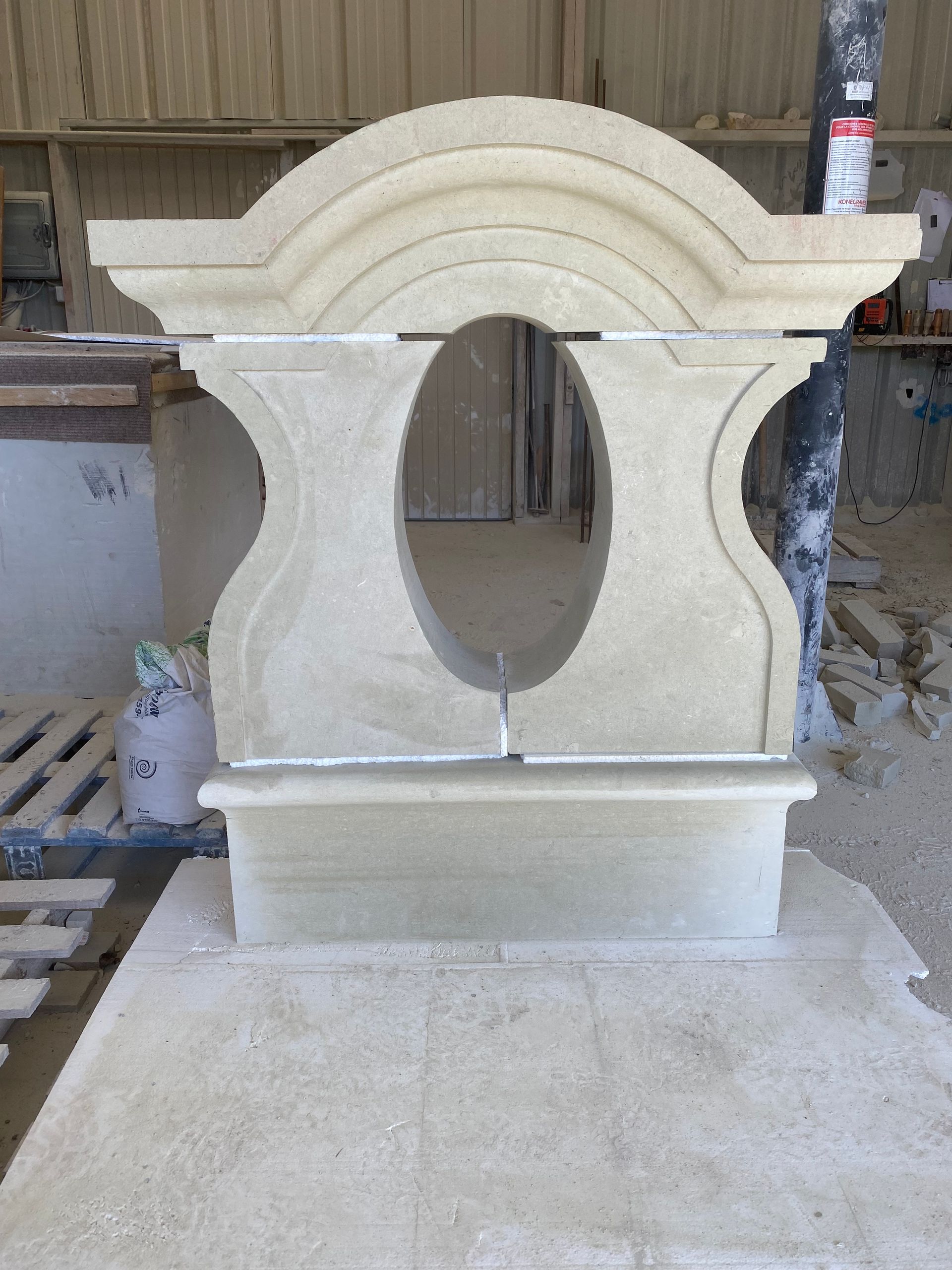 Sculpture en pierre en cours de réalisation ; décor orné avec une ouverture ovale.