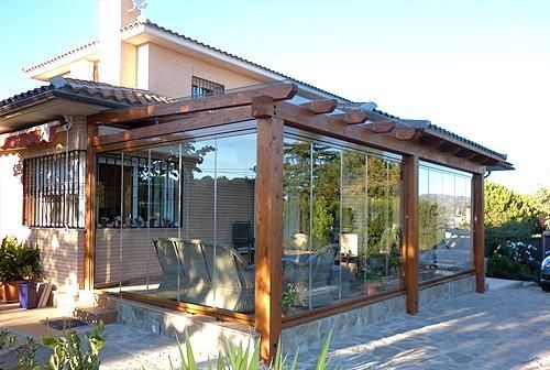 Una casa con pérgola y puertas corredizas de vidrio.