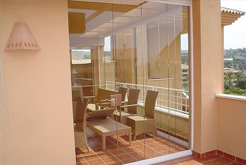 Un balcón con puertas corredizas de vidrio y una mesa y sillas.