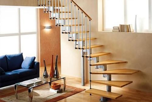 Una sala de estar con una escalera de caracol y un sofá azul.